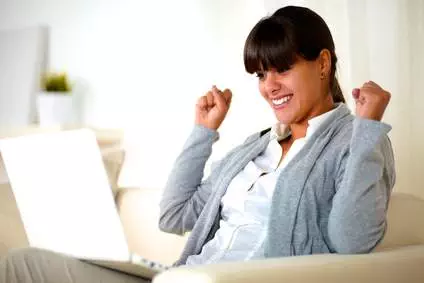 Excited young woman reading the laptop screen