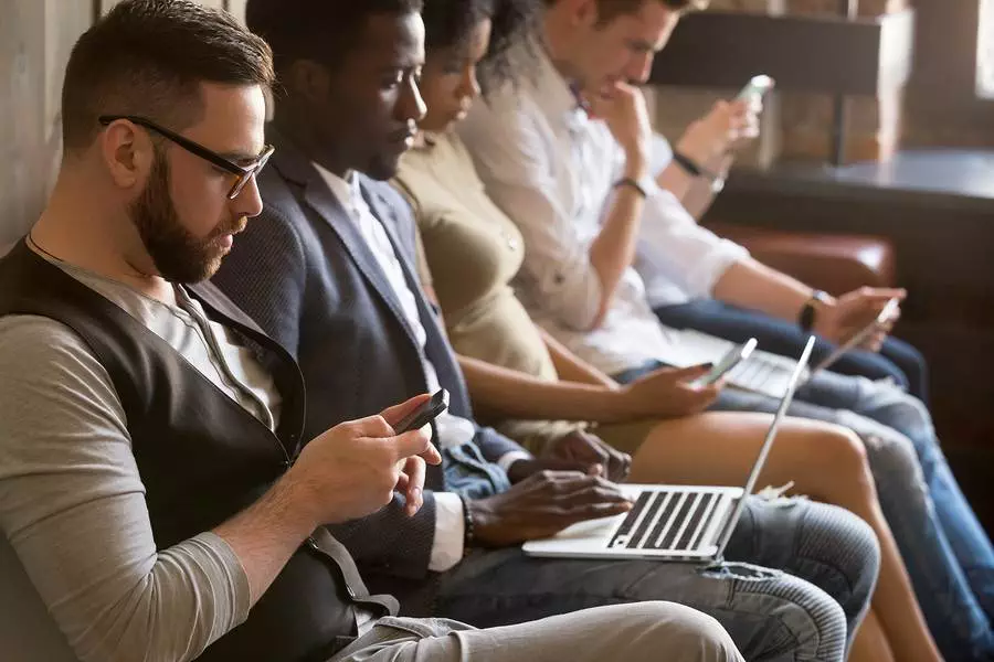 Multi ethnic group of young people using electronic devices indoors